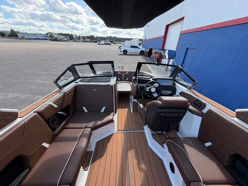Slide: The Image of The image shows the interior of a 2027 Nautique GS22 Super Air boat with brown seating. - 29