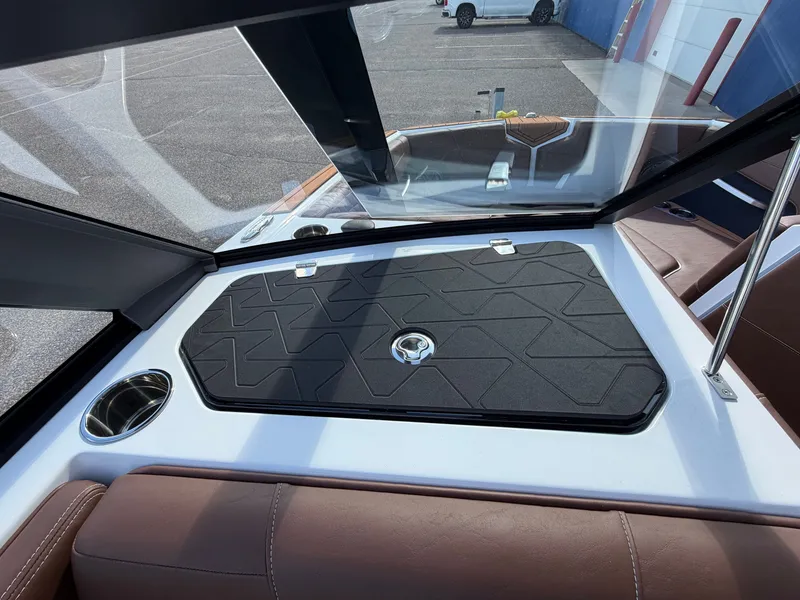 Slide: The Image of The image shows the cockpit of a 2027 Nautique GS22 SUPER AIR with brown seats and a black cover area. - 28