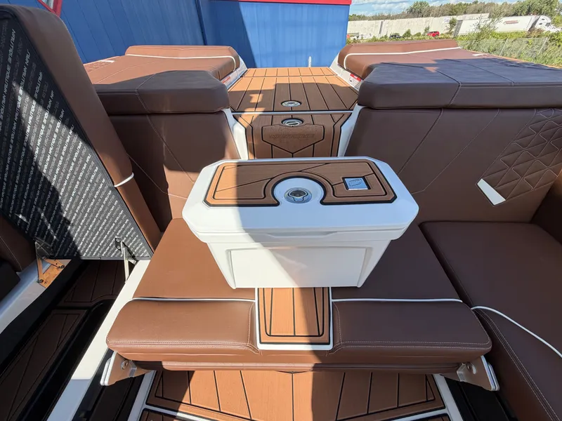 Slide: The Image of The image shows the interior of a 2027 Nautique GS22 Super Air with brown upholstery and a central table. - 37