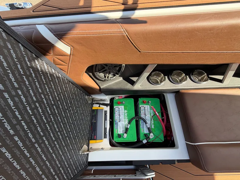 Slide: The Image of Battery compartment of a Nautique GS22 SUPER AIR with brown upholstery and cup holders. - 34