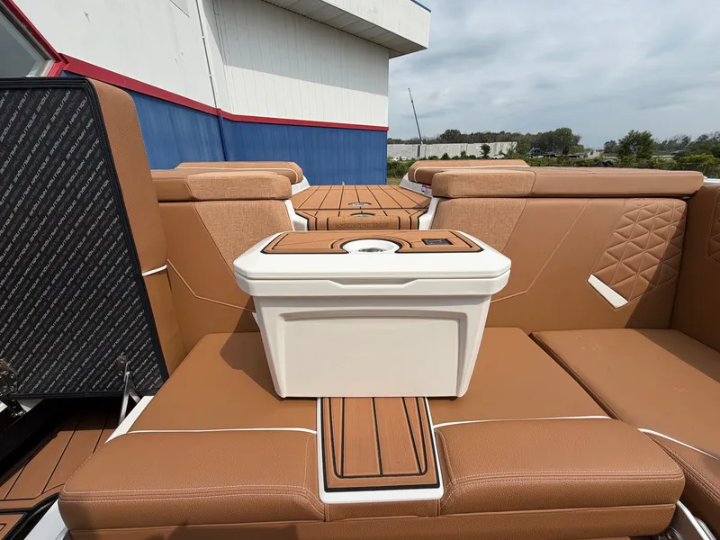 Slide: The Image of The image shows the interior of a 2027 Nautique Super Air Nautique GS24 with brown seats and a white cooler. - 24