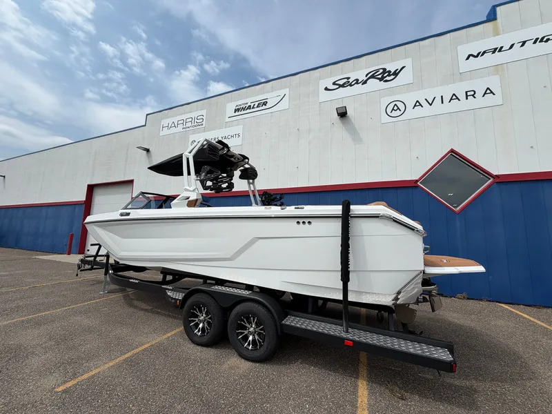 Slide: The Image of A white boat on a trailer in front of a building with various boat brand logos. - 4