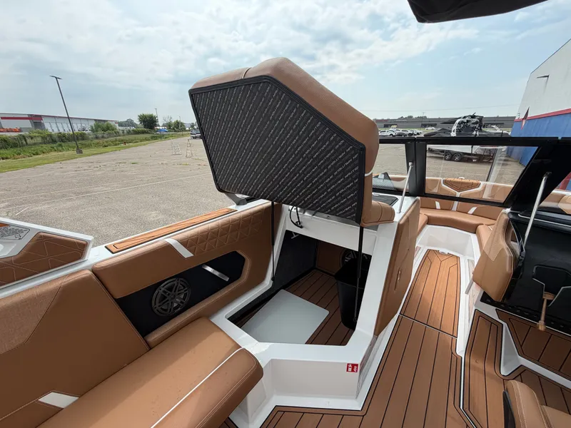 Slide: The Image of The image shows the interior of a 2027 Nautique Super Air Nautique GS24 with brown seating. - 33