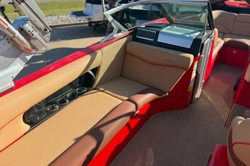 Slide: The Image of 2017 MasterCraft X-46 boat interior with red and tan seating, cup holders, and dashboard. - 14