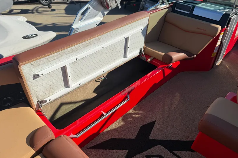 Slide: The Image of 2017 MasterCraft X-46 boat interior with open storage compartment and beige seating. - 17