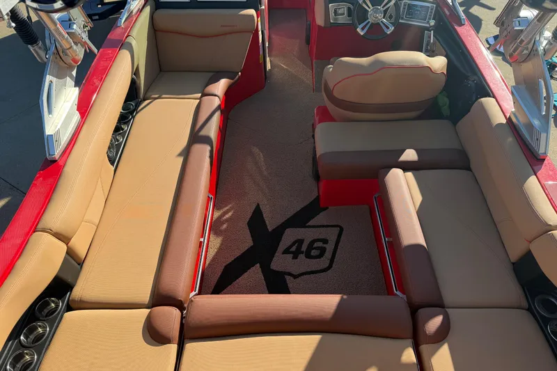 Slide: The Image of 2017 MasterCraft X-46 boat interior with tan and red seating, steering wheel, and dashboard. - 21