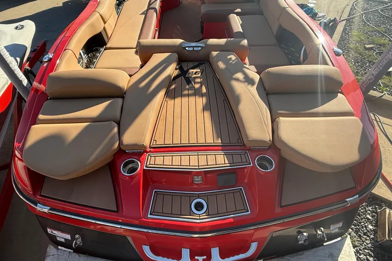 Slide: The Image of 2017 MasterCraft X-46 boat with tan seating and red exterior, viewed from the rear. - 25