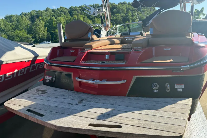 Slide: The Image of 2017 MasterCraft X-46 boat with red exterior and spacious seating, docked outdoors. - 26