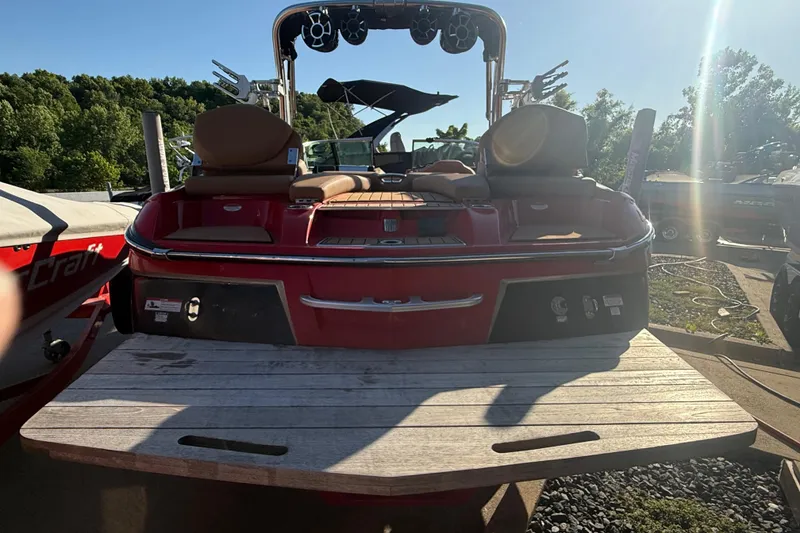 Slide: The Image of 2017 MasterCraft X-46 boat with red exterior and seating, parked outdoors. - 27