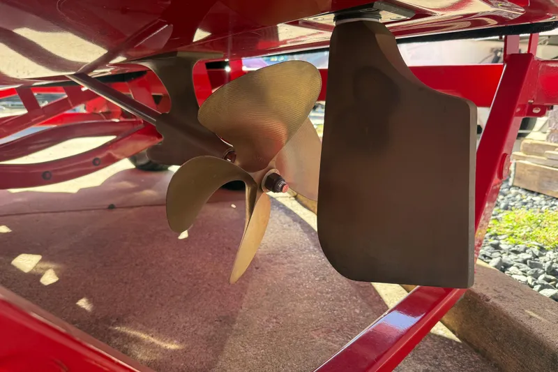 Slide: The Image of Propeller and rudder of a 2017 MasterCraft X-46 boat, showcasing red hull details. - 28