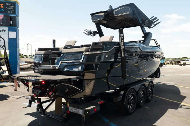 Slide: The Image of 2026 MasterCraft XStar 25 boat on trailer, displayed outdoors under clear sky. - 15
