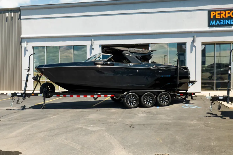 Slide: The Image of 2026 MasterCraft XStar 25 boat on trailer outside marine dealership. - 3
