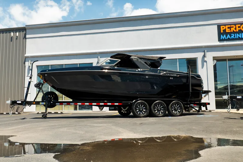 Slide: The Image of 2026 MasterCraft XStar 25 boat on trailer outside marine dealership. - 4