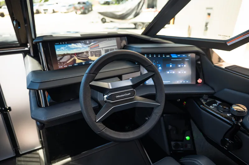 Slide: The Image of 2026 MasterCraft XStar 25 dashboard featuring advanced digital displays and sleek steering wheel design. - 43