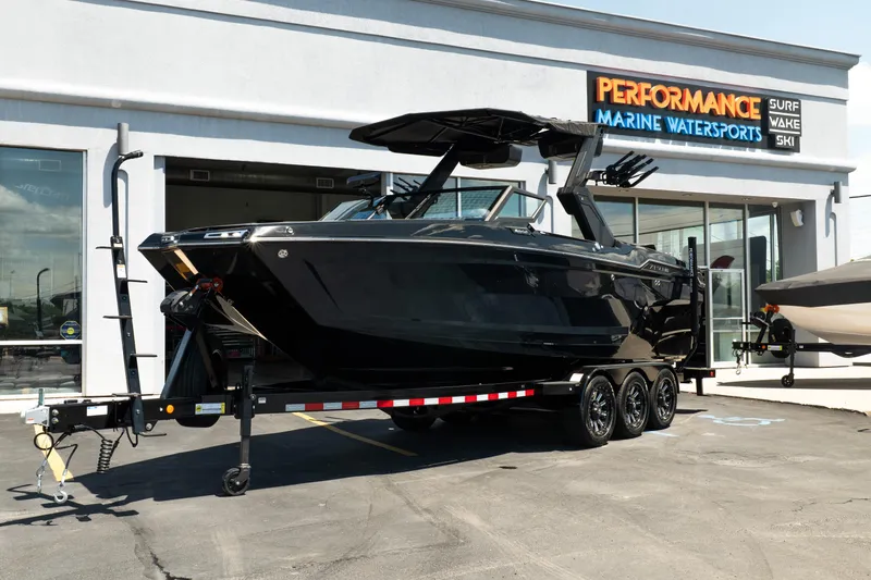 Slide: The Image of 2026 MasterCraft XStar 25 boat on trailer at Performance Marine Watersports dealership. - 5