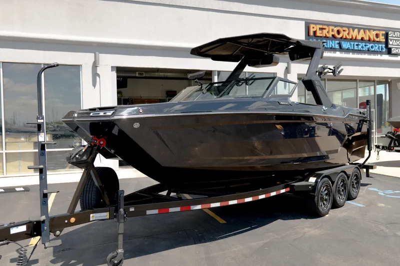 Slide: The Image of 2026 MasterCraft XStar 25 boat on trailer outside Performance Marine Watersports shop. - 56