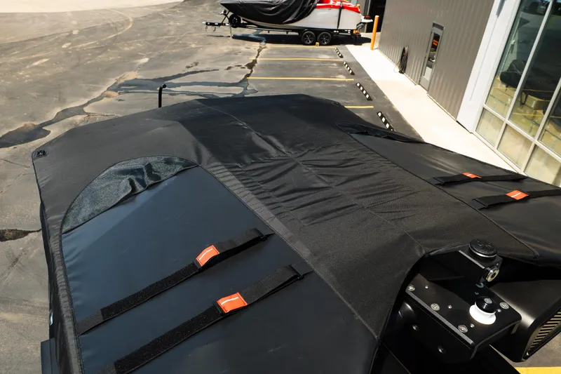 Slide: The Image of 2026 MasterCraft XStar 25 boat with protective cover in a parking area. - 58