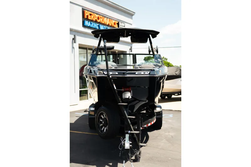 Slide: The Image of 2026 MasterCraft XStar 25 boat displayed at a marine dealership. - 72