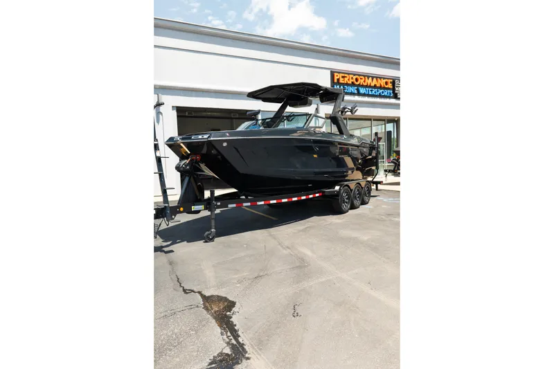 Slide: The Image of 2026 MasterCraft XStar 25 boat on trailer outside marine dealership. - 73
