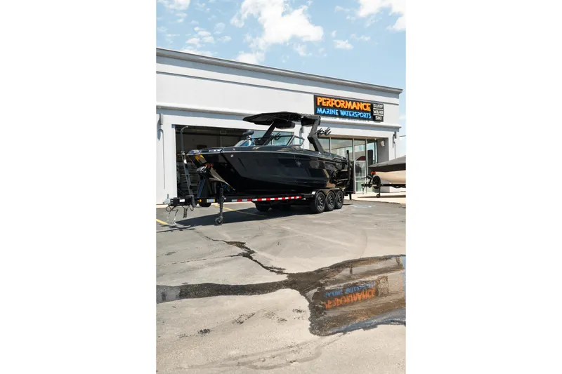 Slide: The Image of 2026 MasterCraft XStar 25 boat on trailer outside marine dealership. - 74