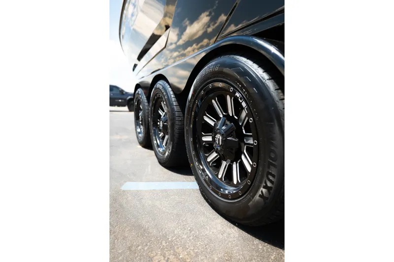 Slide: The Image of Close-up of 2026 MasterCraft XStar 25 trailer wheels, showcasing sleek black rims and tires. - 75
