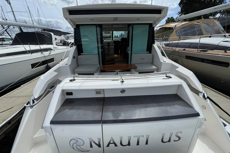 Slide: The Image of 2018 Tiara Yachts C44 Coupe, rear view, docked with open cockpit and seating area. - 11
