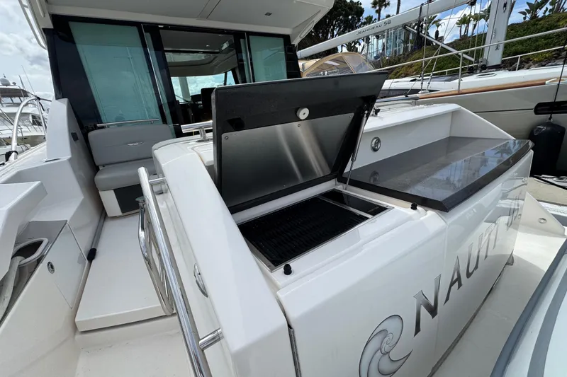 Slide: The Image of 2018 Tiara Yachts C44 Coupe with open grill on deck, docked at marina. - 12