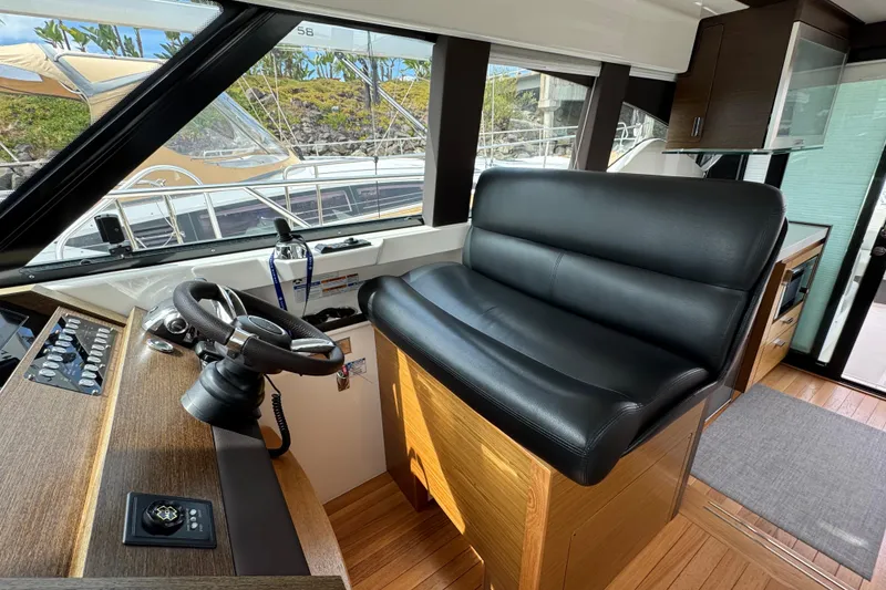 Slide: The Image of Interior of 2018 Tiara Yachts C44 Coupe with leather seating and steering wheel. - 18