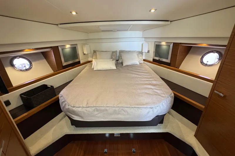 Slide: The Image of Luxurious bedroom interior of 2018 Tiara Yachts C44 Coupe with elegant bedding and porthole windows. - 24