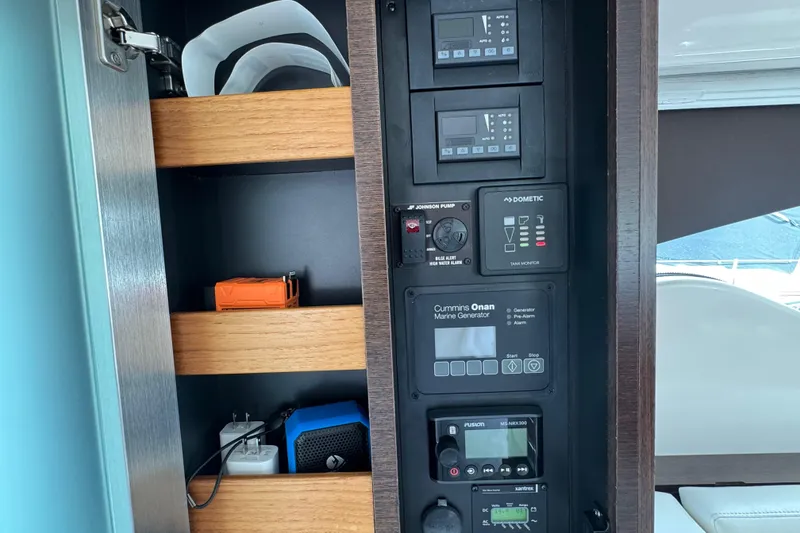 Slide: The Image of Control panel and storage shelves inside a 2018 Tiara Yachts C44 Coupe. - 39
