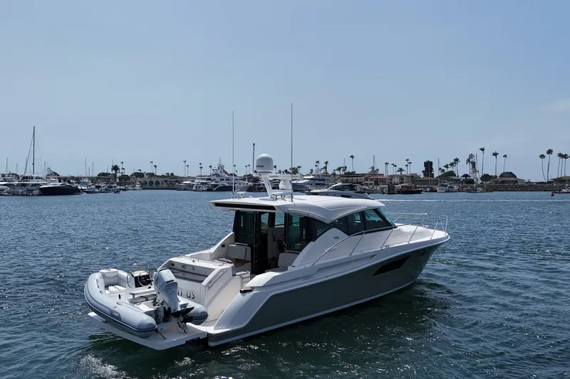 Slide: The Image of 2018 Tiara Yachts C44 Coupe cruising in a marina with palm trees in the background. - 6