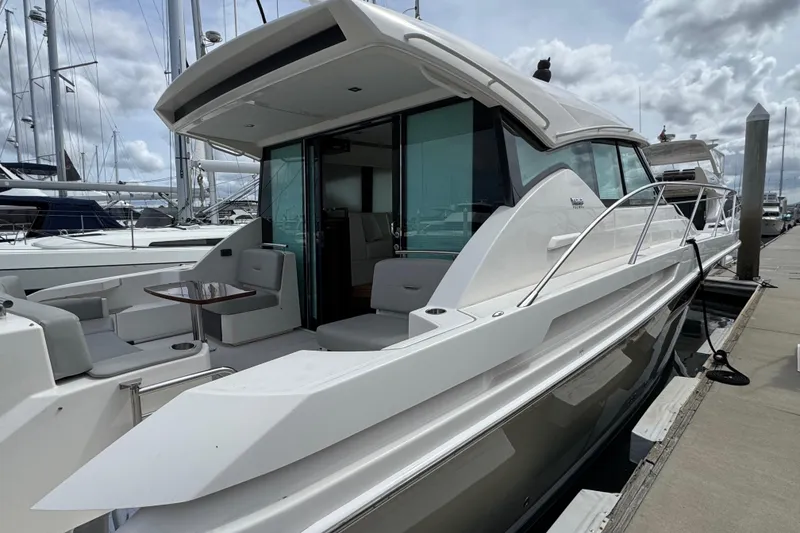Slide: The Image of 2018 Tiara Yachts C44 Coupe docked, showcasing sleek design and spacious deck area. - 9