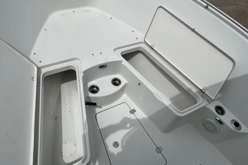 Slide: The Image of 2008 Sailfish 2360 CC boat interior with open storage compartments and cup holders. - 16