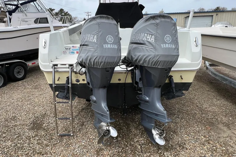 Slide: The Image of 2008 Sailfish 2360 CC boat with twin Yamaha outboard motors, parked on gravel. - 5