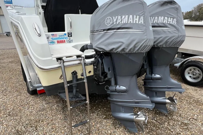 Slide: The Image of 2008 Sailfish 2360 CC boat with dual Yamaha outboard motors, ladder, and branded stickers. - 6