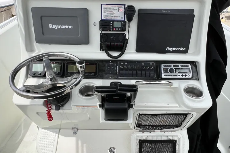 Slide: The Image of 2008 Sailfish 2360 CC boat dashboard with Raymarine electronics and steering wheel. - 9
