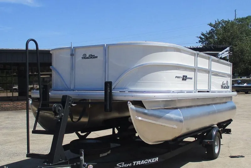 Slide: The Image of 2026 Sun Tracker Party Barge 16 DLX pontoon boat on trailer, parked outdoors. - 11