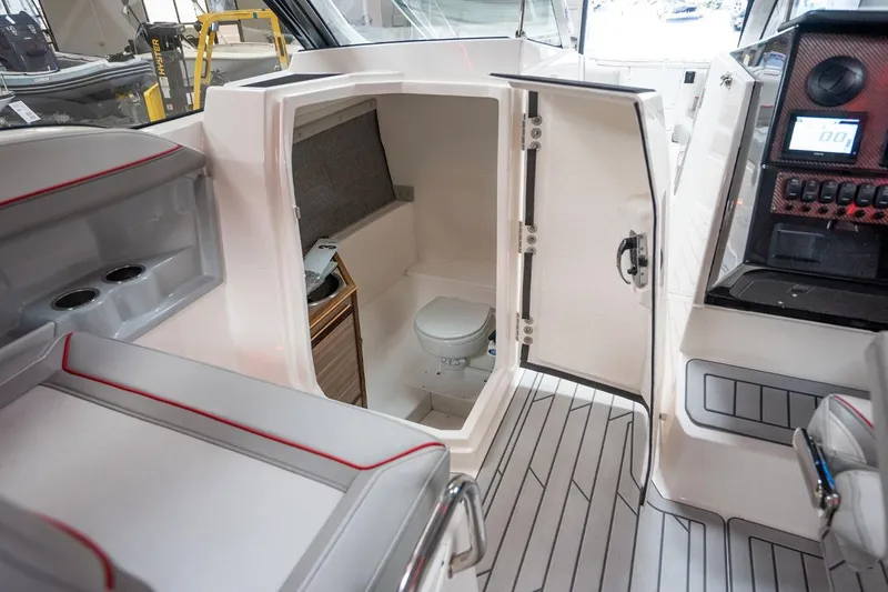 Slide: The Image of 2024 Solara S250 Dual Console boat interior with open door revealing compact restroom. - 10