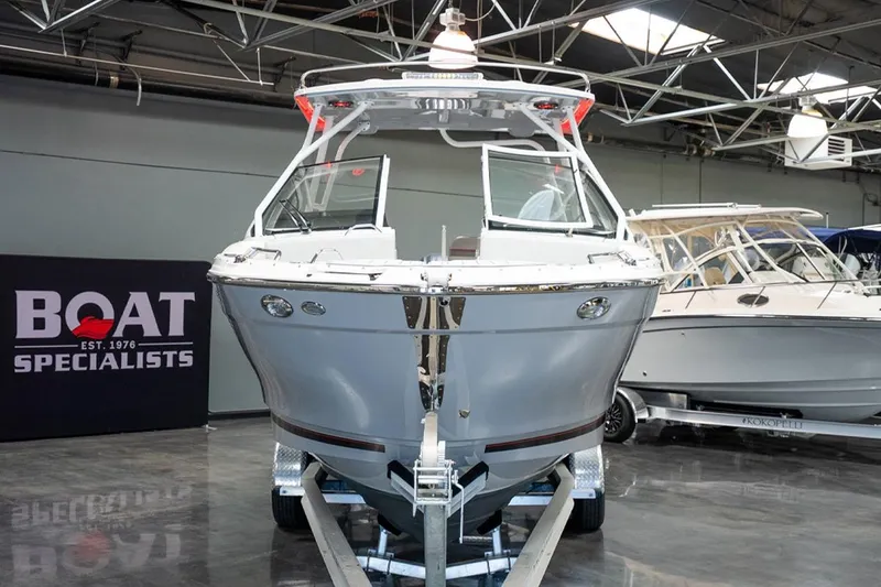 Slide: The Image of 2024 Solara S250 Dual Console boat displayed indoors at a boat specialist showroom. - 2