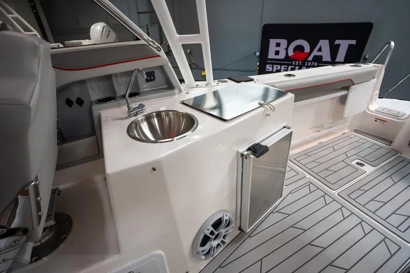Slide: The Image of 2024 Solara S250 Dual Console boat interior with sink, fridge, and modern flooring. - 8