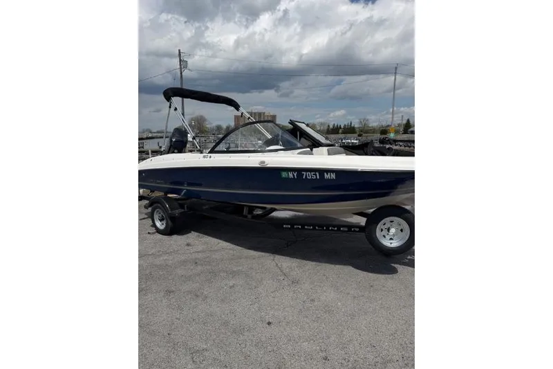 Slide: The Image of 2017 Bayliner 160 Bowrider on trailer, parked outdoors under cloudy sky. - 10