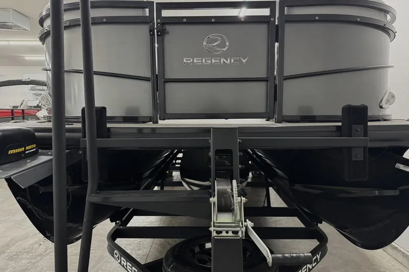 Slide: The Image of 2017 Regency 254 LE3 pontoon boat on trailer in garage setting. - 3