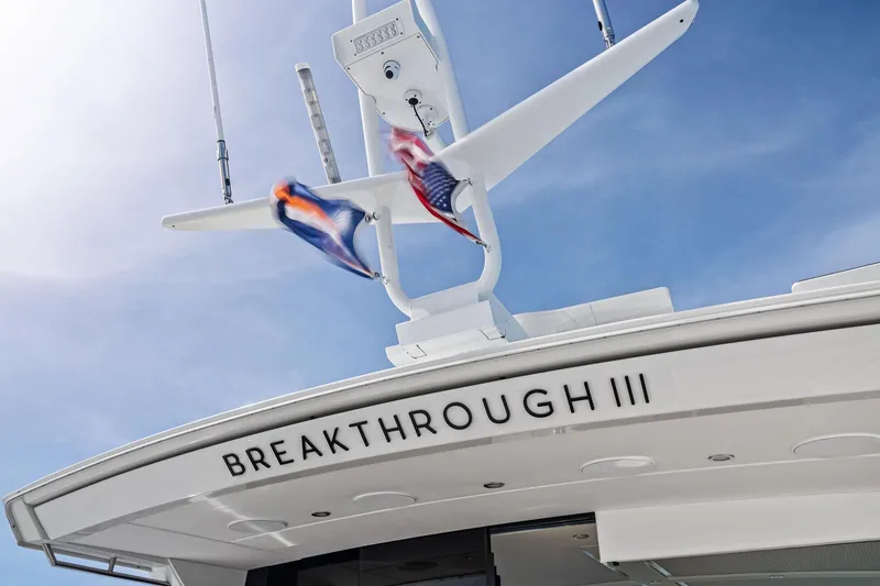 Slide: The Image of 2025 Formula 500 Super Sport Crossover yacht, "Breakthrough III," with flags against blue sky. - 57