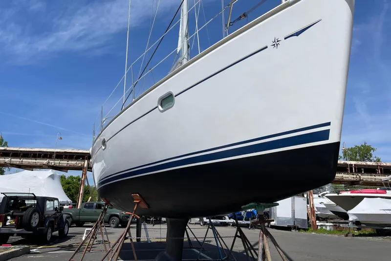 Slide: The Image of 2003 Jeanneau Sun Odyssey 35 sailboat on stands, ready for maintenance under a clear blue sky. - 2
