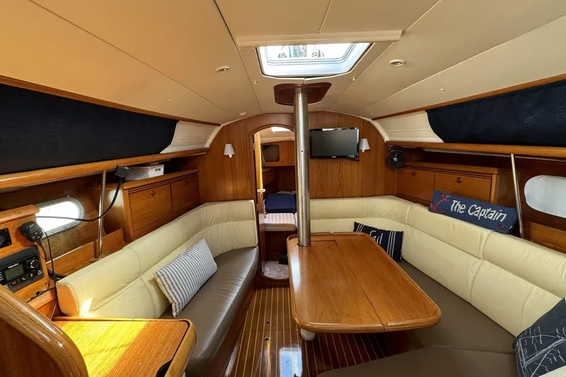 Slide: The Image of Interior of 2003 Jeanneau Sun Odyssey 35 sailboat with cozy seating and wooden finishes. - 4