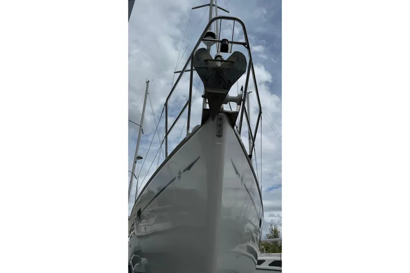 Slide: The Image of 2003 Jeanneau Sun Odyssey 35 sailboat, viewed from the bow, under a cloudy sky. - 7