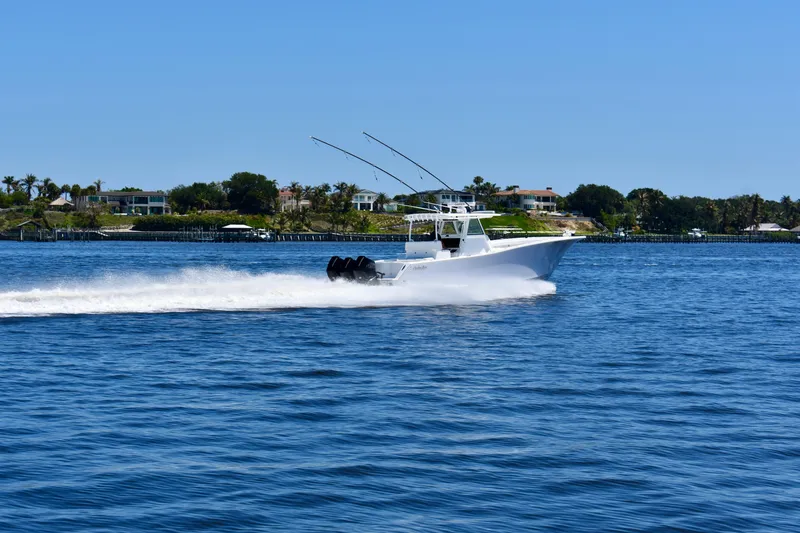 Slide: The Image of 2022 Onslow Bay 41 Tournament boat speeding on a sunny day near coastal homes. - 18