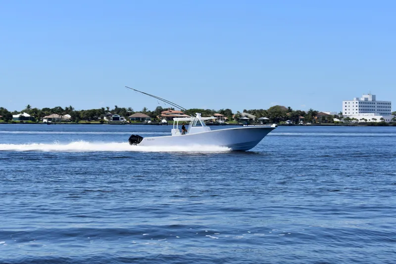Slide: The Image of 2022 Onslow Bay 41 Tournament boat cruising on a sunny day near coastal homes. - 21