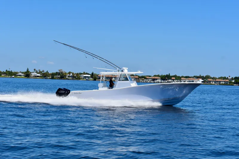 Slide: The Image of 2022 Onslow Bay 41 Tournament boat cruising on a sunny day, with coastal homes in the background. - 25