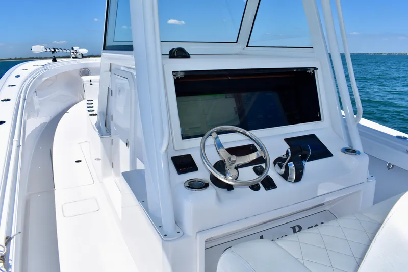 Slide: The Image of 2022 Onslow Bay 41 Tournament boat helm with steering wheel and controls on open water. - 3